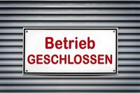 Betrieb geschlossen Schild vor einem geschlossenen Rollladen.