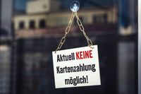 Ein Schild an einer Glastür mit der Aufschrift 'Aktuell KEINE Kartenzahlung möglich!', das auf eine Störung bei der EC-Zahlung hinweist.