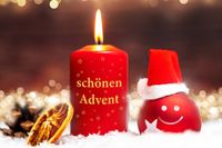 Lustiger Advent mit lachender Weihnachtskugel im Nikolaushut und einer brennenden Kerze mit der Aufschrift 'Schönen Advent'