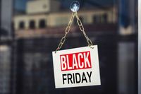 Black Friday steht auf einem Schild, das an einer Glastür hängt – Symbol für bevorstehende Black Friday Sales und Rabatte.