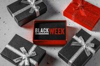 Geschenkboxen mit der Aufschrift Black Week, die Black Friday-Angebote ankündigt, umgeben von weiteren Geschenkverpackungen – ein typisches Black Week Bild.