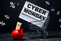 Einkaufswagen mit einem Cyber Monday Schild und einem roten Sparschwein mit einem 50-Euro-Schein im Hintergrund – ein typisches Cyber Monday Bild.