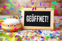 Fasching geöffnet, geänderte Öffnungszeiten auf einem Schild an Karneval