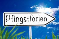 Schild mit der Schrift ‚Pfingstferien‘ vor blauem Himmel, passend zu den Pfingstferien 2025.