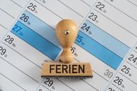 Stempel mit der Aufschrift ‚Ferien‘ auf einem Kalender, der Winterferien 2025 markiert.