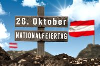 26. Oktober Nationalfeiertag, steht auf einem Holzschild vor einem blauen Himmel und der österreichischen Flagge im Hintergrund. Das Bild steht symbolisch für den Nationalfeiertag Österreichs, der jedes Jahr am 26. Oktober gefeiert wird.