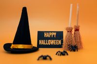 Hexenhut, Besen, Spinnen und Karte mit Halloween Spruch 'Happy Halloween', in Farbton Orange gehalten.