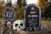 Gruselige Halloween-Bilder auf einem Friedhof: Grabsteine mit Aufschriften wie 'RIP' und 'Happy Halloween', begleitet von einem gruseligen Totenkopf, der eine schaurige Atmosphäre schafft.