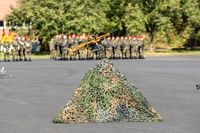 Waffe in Felcktarn, vor Soldaten der Bundeswehr.