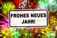 Schild mit 'Frohes Neues Jahr' vor buntem Feuerwerk, passend für Neues Jahr Wünsche