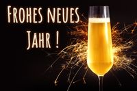 Silvesterbild mit Sektglas, Wunderkerze, Aufschrift frohes neues Jahr, für Neujahrsfeier.