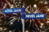 Jahreswechsel-Straßenschilder mit Altes Jahr und Neues Jahr vor Feuerwerk.