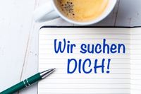 Wir suchen DICH! steht auf einem Block welches auf einem Büro-Tisch liegt, daneben ein Stift und eine Tasse Kaffee. Das Bild vermittelt eine persönliche Ansprache in der Du-Form.