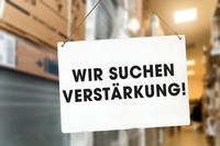 Stellenanzeige Logistik – Wir suchen Verstärkung im Lagerbereich mit einem Schild im Lagerumfeld. Suche nach Fachkraft für Lagerlogistik.