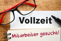 Vollzeitstelle, Mitarbeiter gesucht - Nahaufnahme eines Notizblocks mit Text und Brille auf einem Schreibtisch.