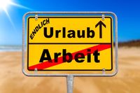 Schild mit der Aufschrift „Endlich Urlaub“, das „Arbeit“ durchgestrichen zeigt, im Hintergrund ein sonniger Strand.