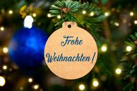 Holzdekoration, auf der die Worte Frohe Weihnachten steht.