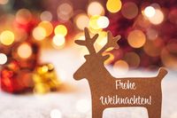 Rentier mit Schriftzug frohe Weihnachten Text vor bunten Lichtern.