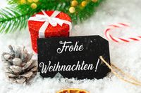 Frohe Weihnachten - festliches Bild mit Geschenk, Tannenzapfen und Weihnachtsdekoration.