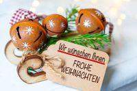 Geschäftliche Weihnachtsgrüße mit Glocken und Geschenkanhänger, festliche Dekoration.