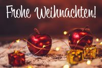 Frohe Weihnachten WhatsApp mit roten Äpfeln und goldenen Geschenken, umrahmt von Lichtern.