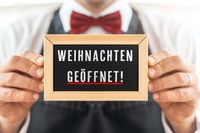 Weihnachten geöffnet, Schild gehalten von Kellner.