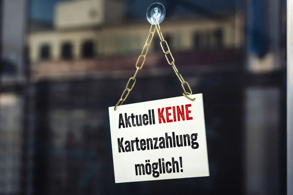 Ein schild an einer glastür mit der aufschrift 'aktuell keine kartenzahlung möglich! ', das auf eine störung bei der ec-zahlung hinweist.