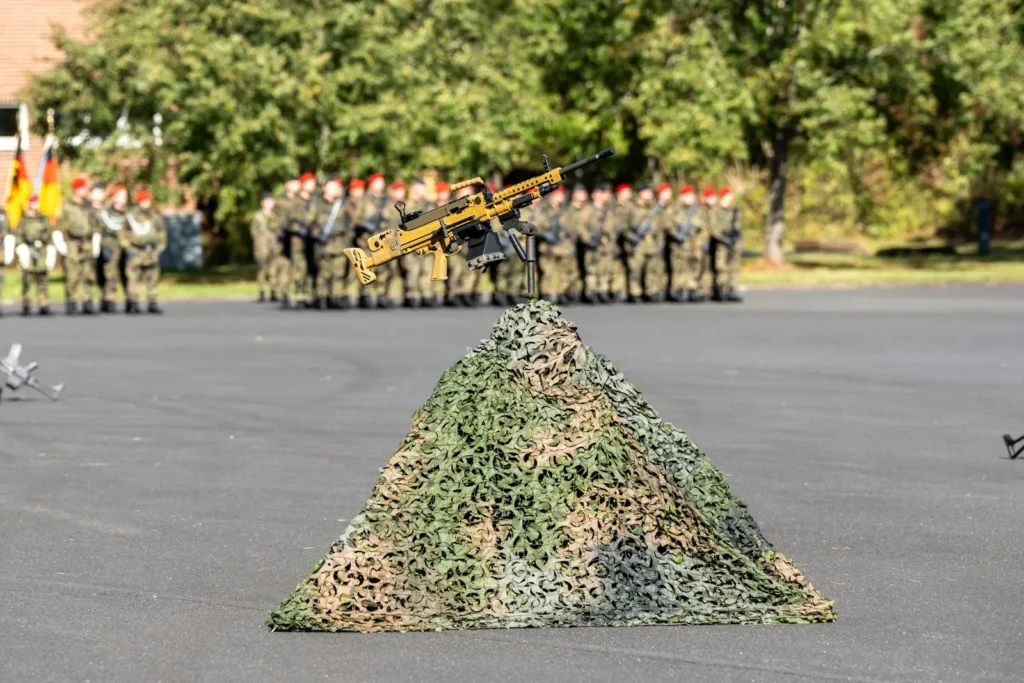 Waffe in Felcktarn, vor Soldaten der Bundeswehr.