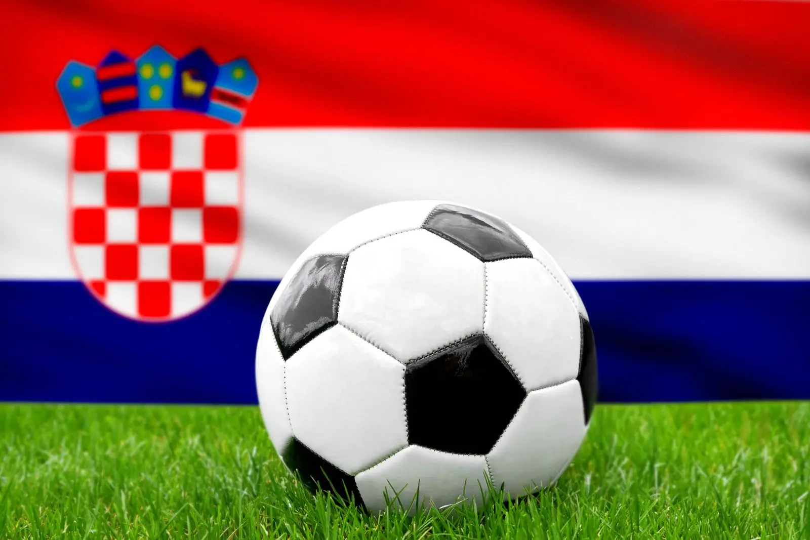 Ein fusball vor der kroatischen fahne reprasentiert die nationalmannschaft von kroatien im fusball