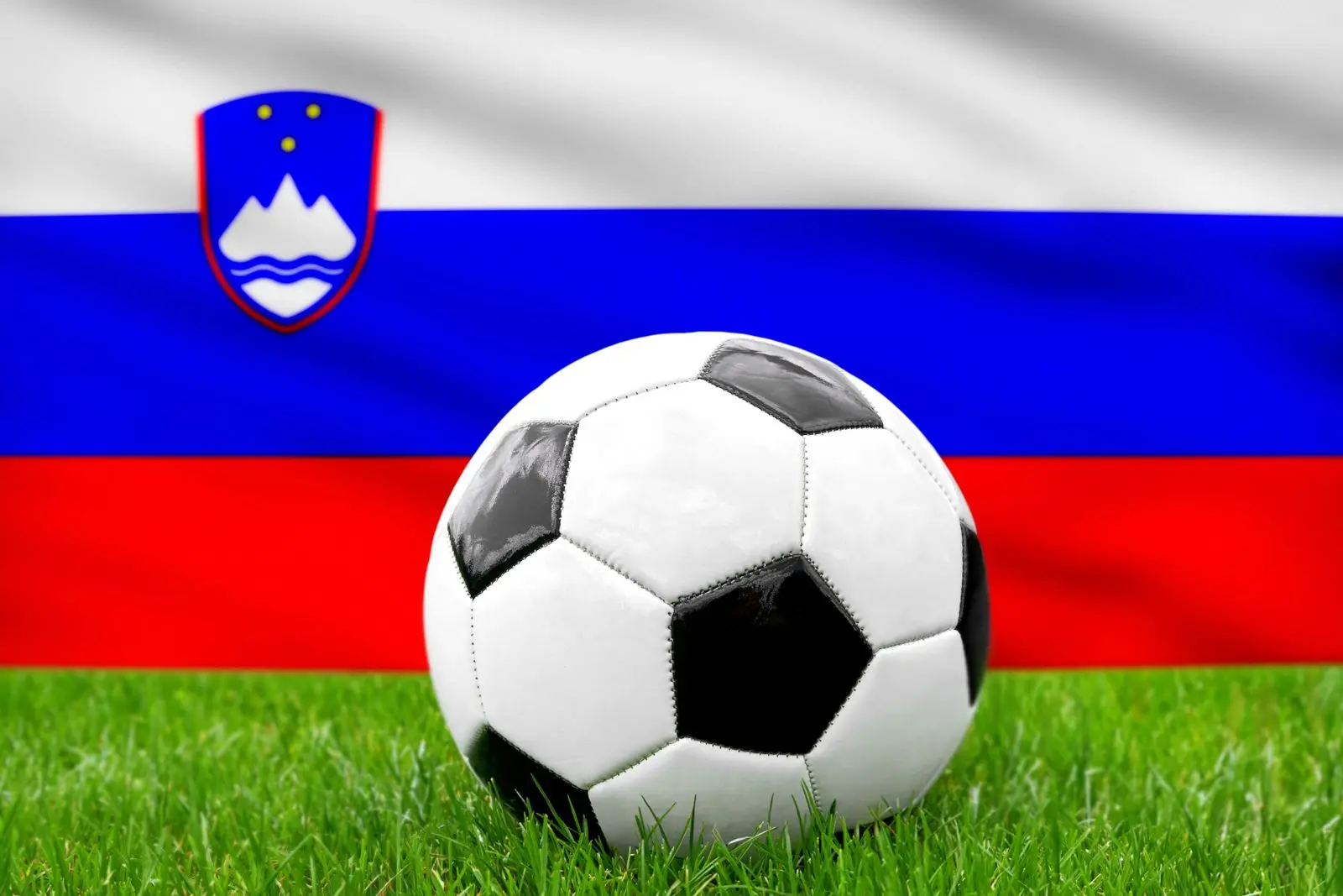 Ein fusball vor der slowenischen fahne steht fur die nationalmannschaft von slowenien im fusball